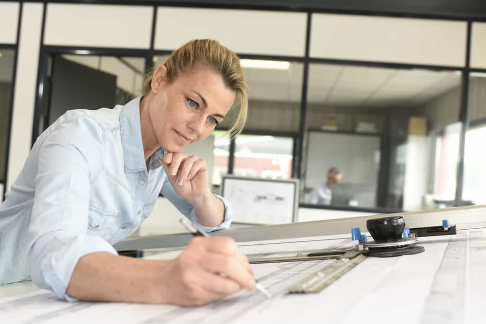 A woman drawing up plans for a an architectural project.