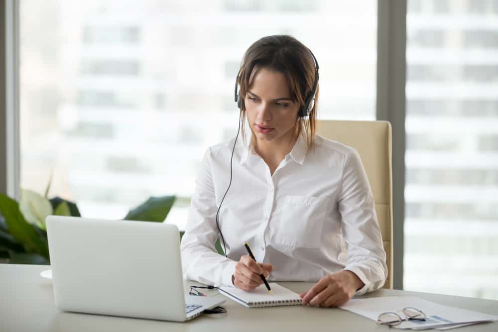 A translator watching a video and making notes.