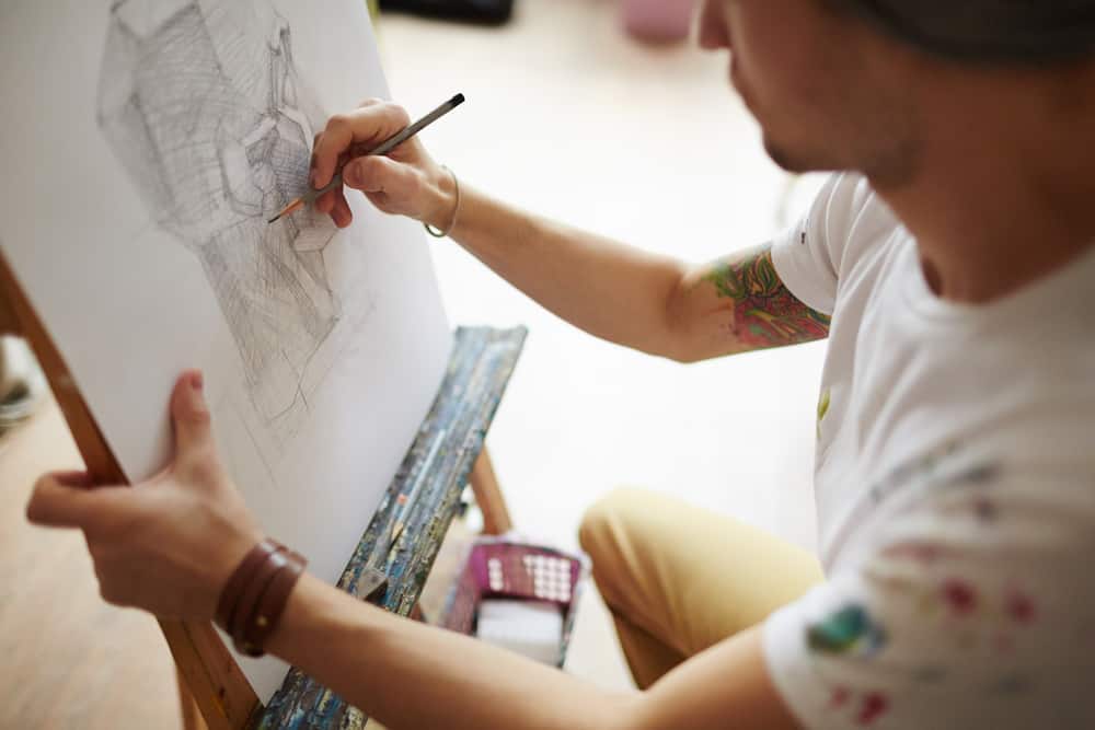 An illustrator at work on a sketch with a pencil.