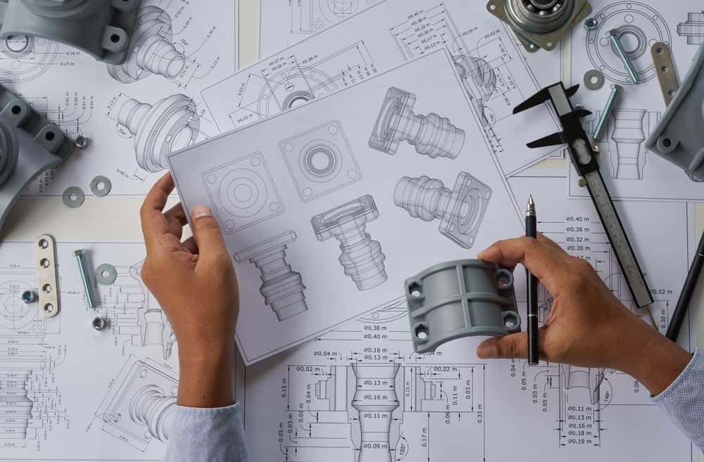 An industrial designer working on small parts of a machine.