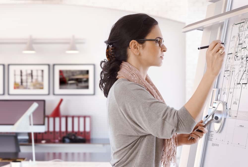 Architect drawing up plans on an upright board.