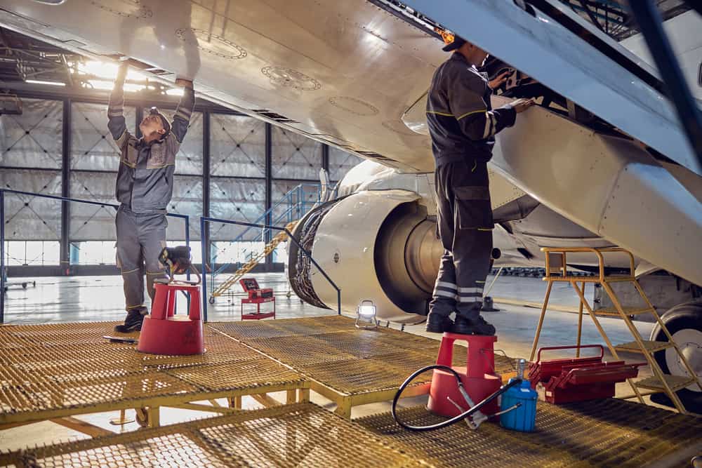 Aero mechanical technician fixing and checking spoiler and flaps on the airplane.