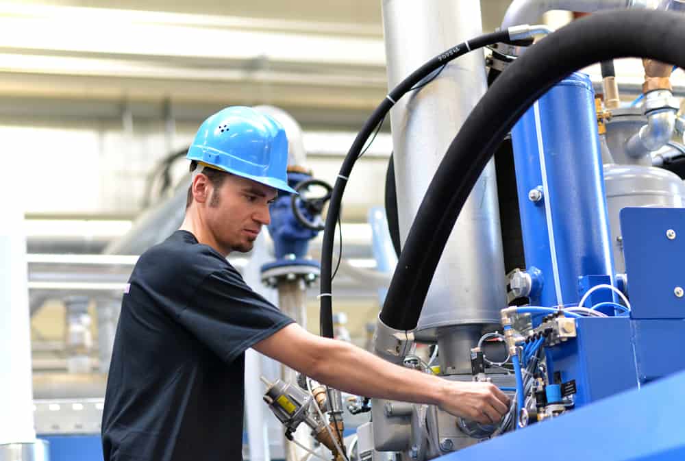 Hydraulic, pneumatic technician repairing a machine.