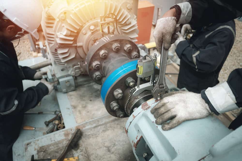 Pump technician repairing pump and electric motor.