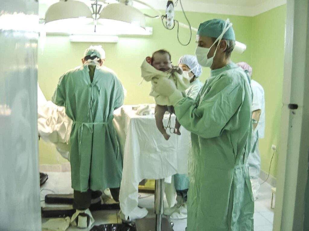 Perinatal nurse holding the newborn baby.