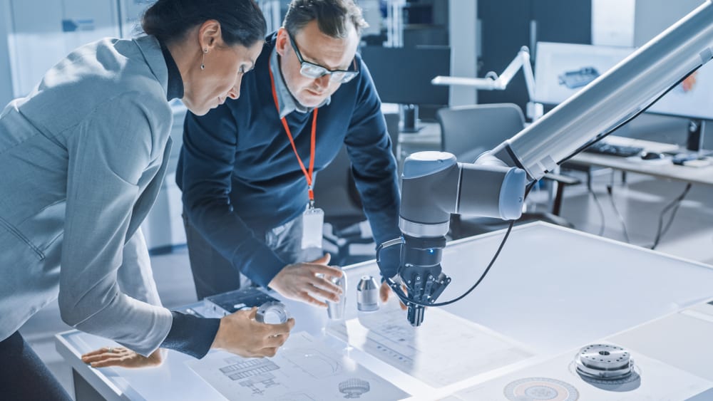 Mechanical engineers working on a robot arm.