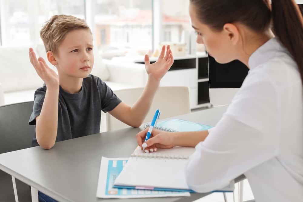 Behavioral analyst talking to a young boy.