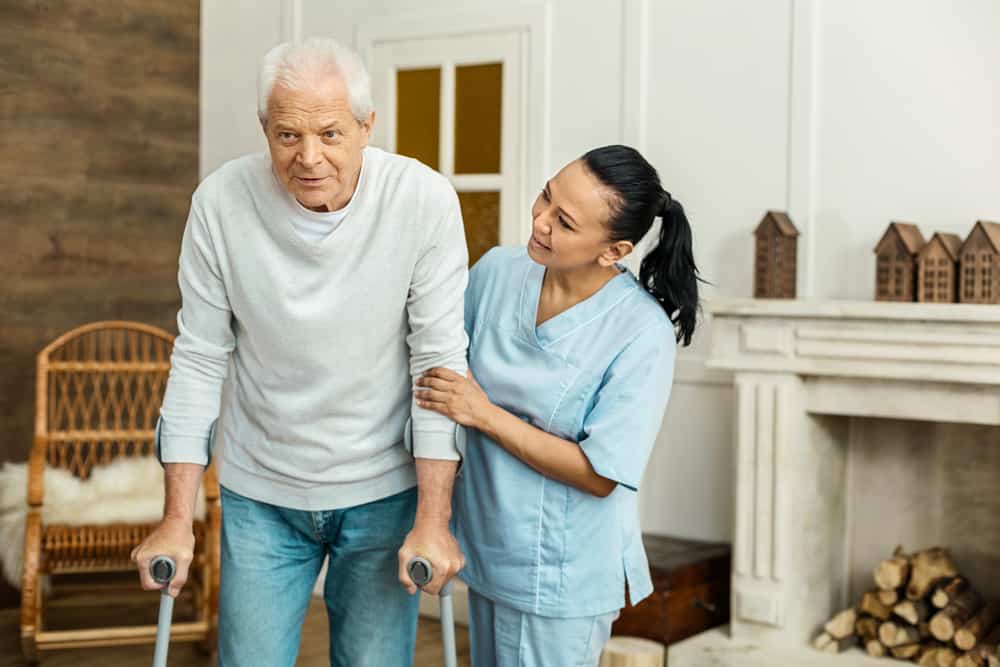 Caregiver assisting senior on walking.