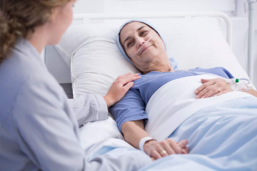 Hospice social worker caring for the elder woman with tumor.