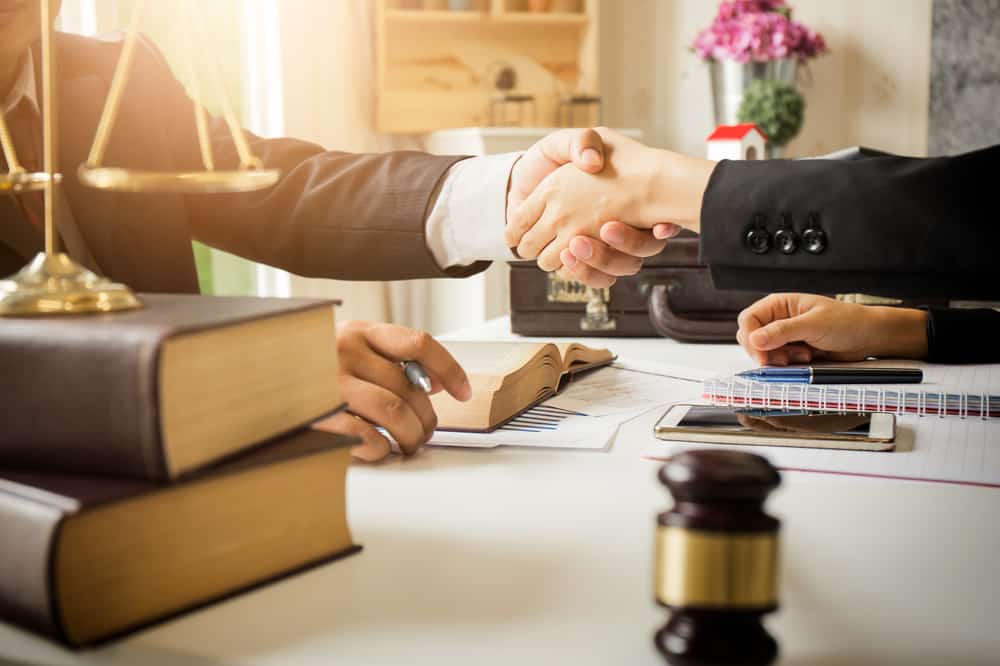 Lawyer and client shake hands in the office.