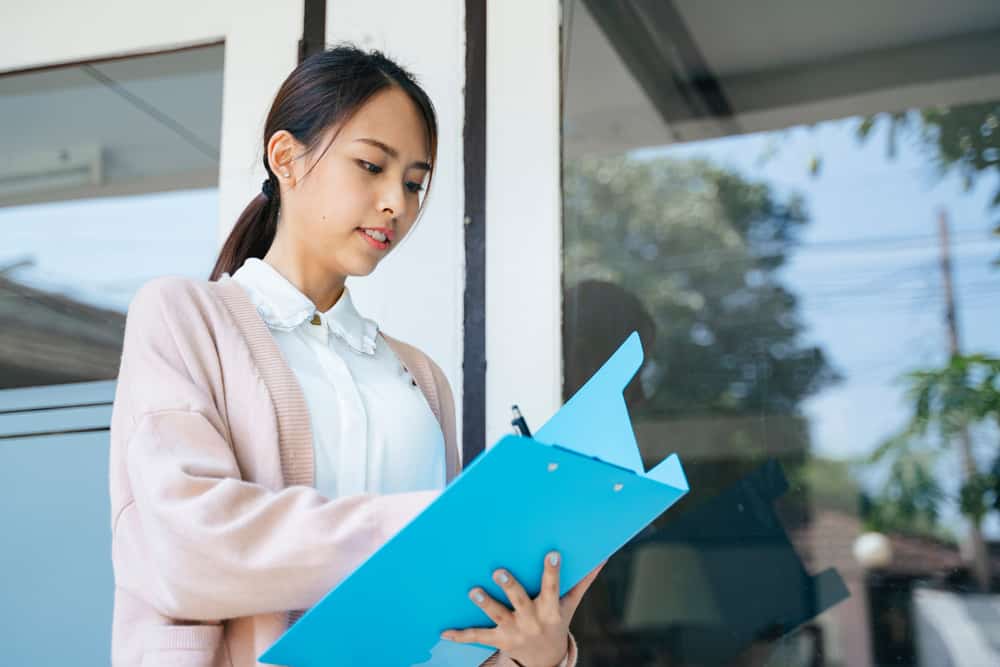 Soldier worker holding a blue binder while taking notes.