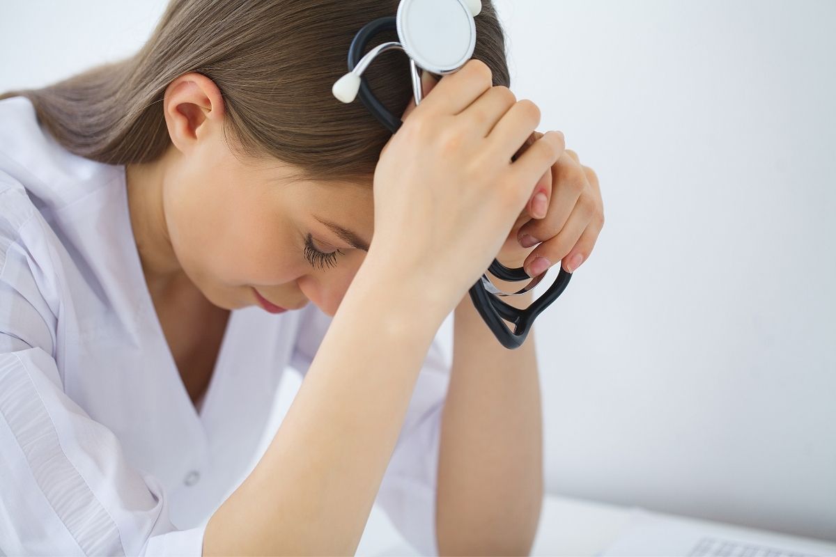 Sad and crying nurse in a hospital office.