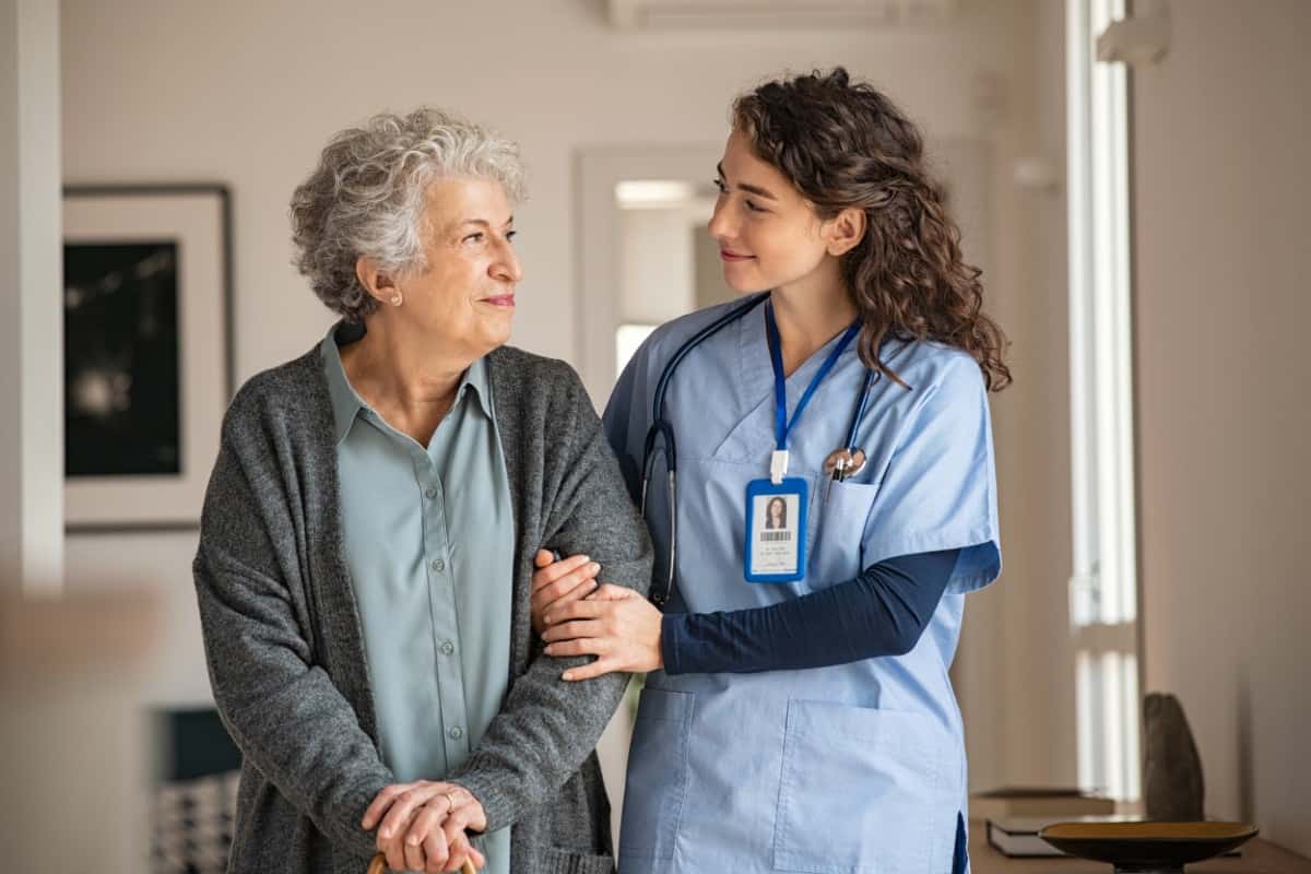 Young nurse assisting senior woman.