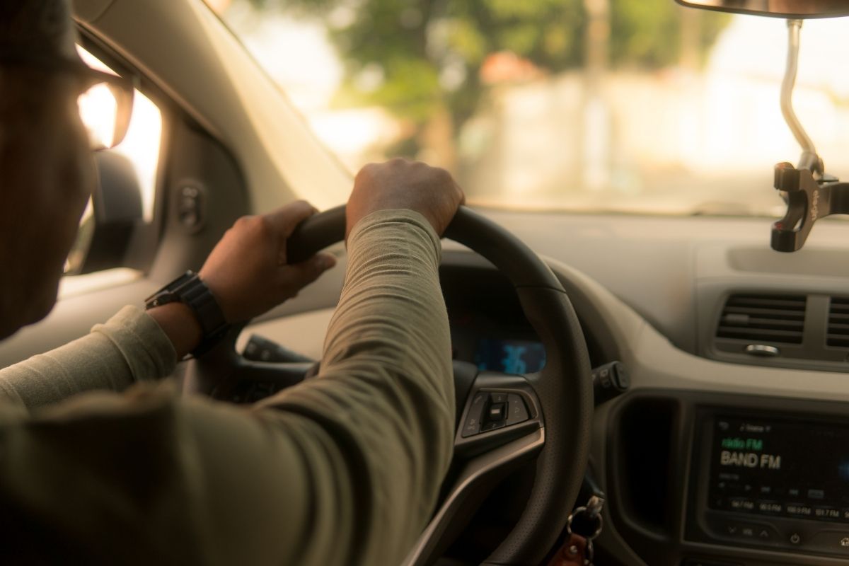 A young person driving a taxi car.