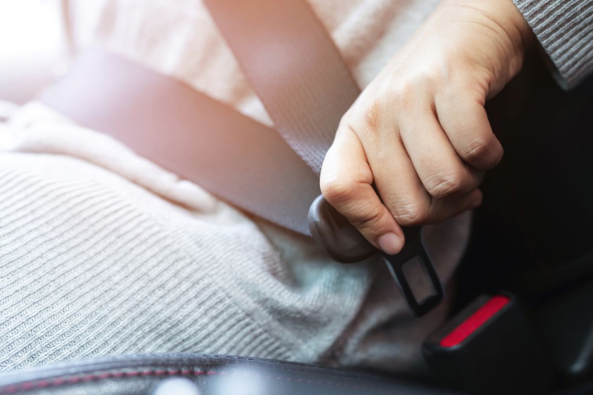 A man wearing his seat belt.