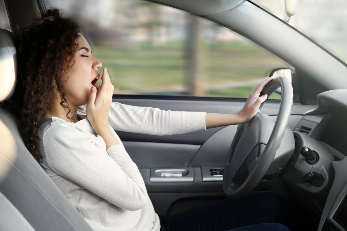 A sleepy woman inside a car.