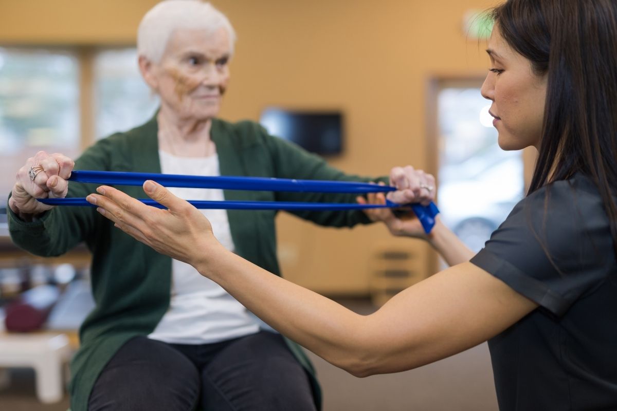 A senior woman works with her occupational therapist.