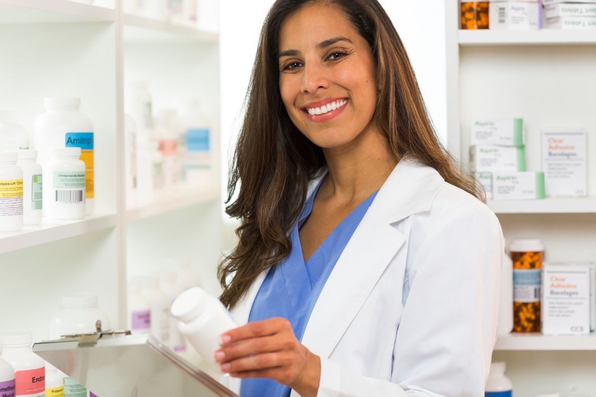 Pharmacist smiling and holding a clipboard.