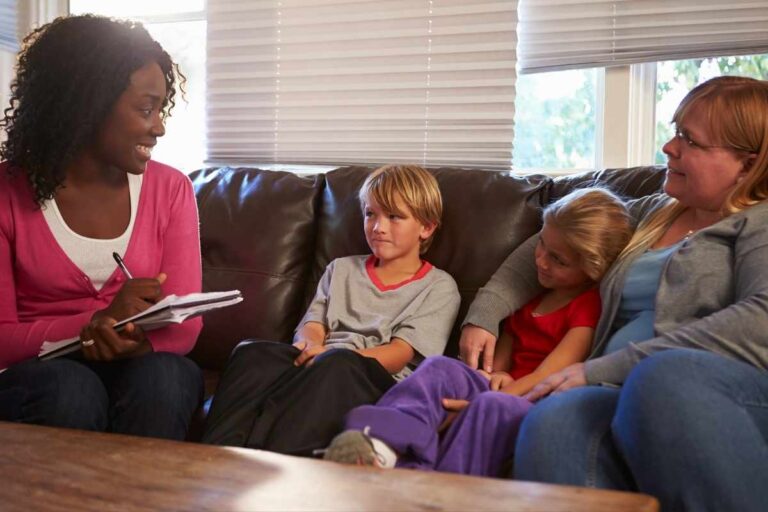 Social worker talking to mother and children at home.